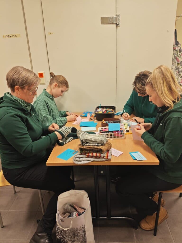 Sotilaskotisisaret lajittelevat villasukkia koon mukaan.